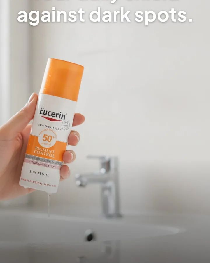 The same bottle held in a bright bathroom, with a headline reading Your daily shield against dark spots