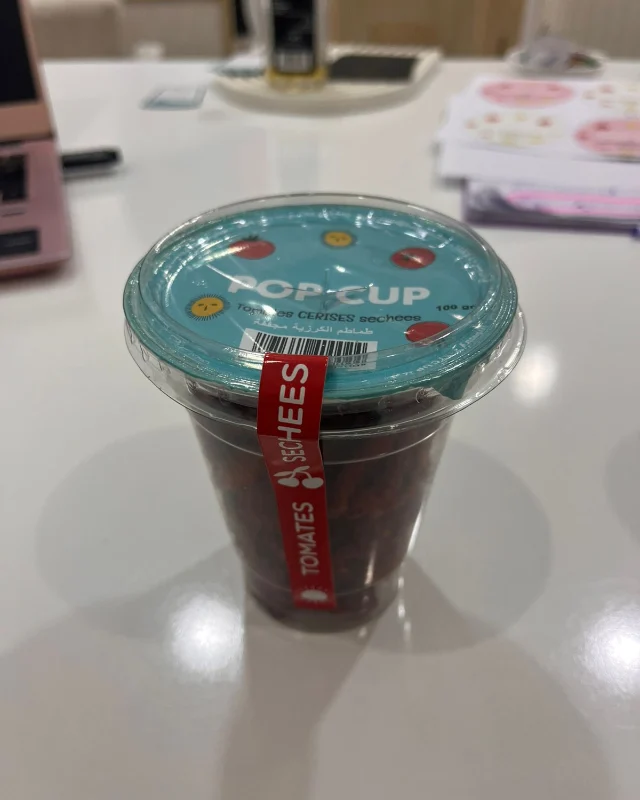 Phone photo of a Pop Cup dried tomato cup on a white desk